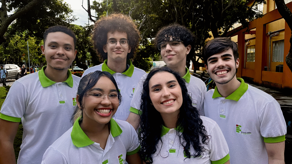 Imagem dos integrantes da equipe Potiguaras em 2025, com o fundo em área verde, levemente mostrando o prédio da Biblioteca Central Sebastião Fernandes, do IFRN Campus Natal - Central.